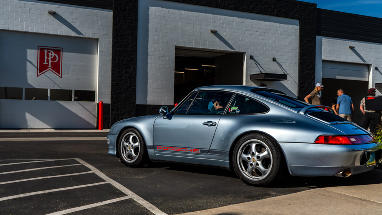 A silver Porsche 911 arriving at the Park Place service entrance