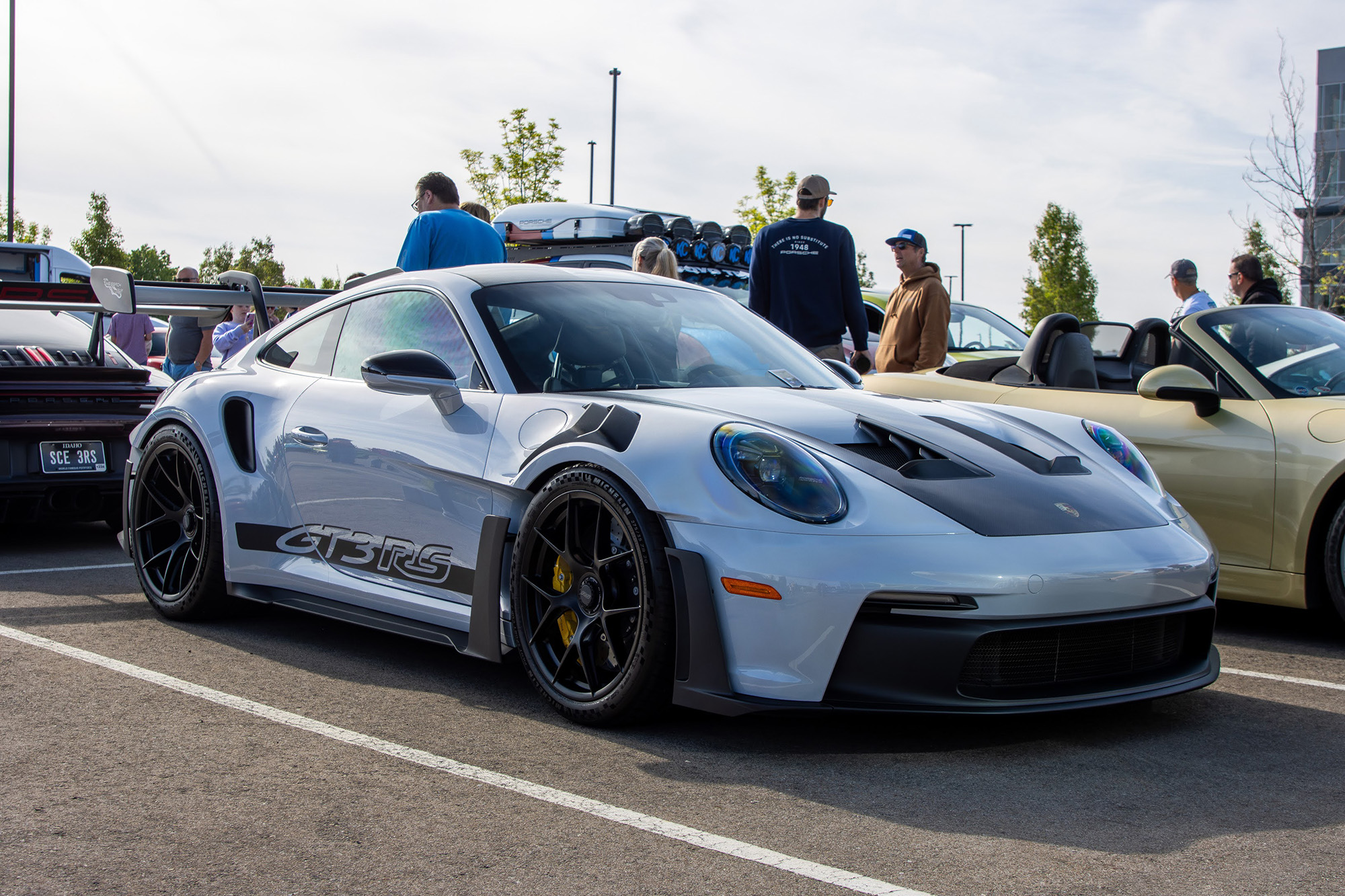 Gray Porsche 911 GT3 RS parked in the modern and exotics area at Idaho Air 2026, with attendees behind it